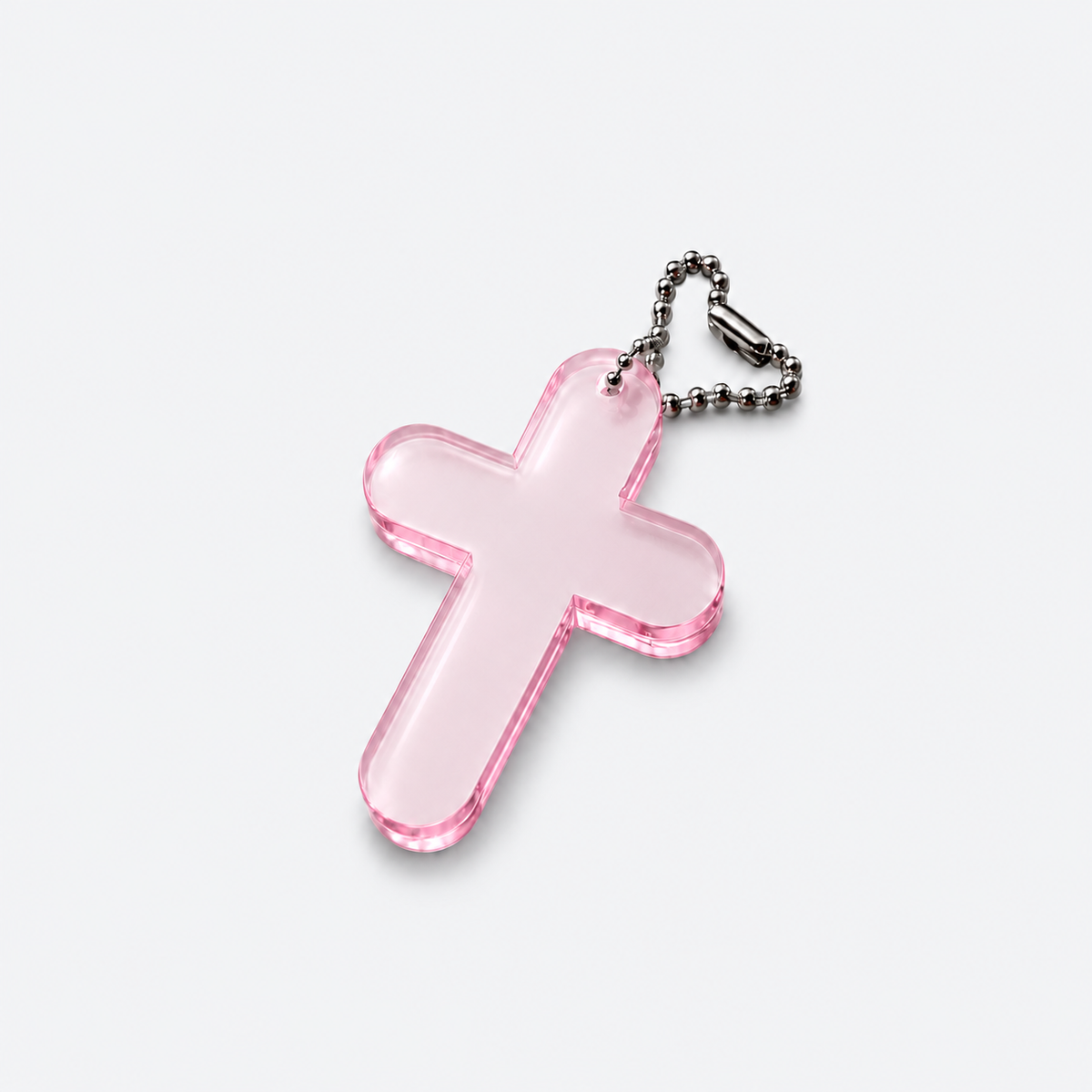 A translucent pink acrylic cross keychain with a silver ball chain, shown on a clean light gray background.