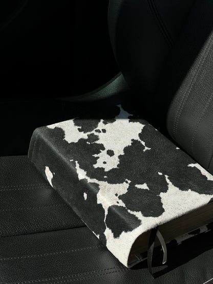 Kainos Bare Black Cow Print Bible Cover sitting in car